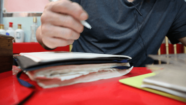 Person writing in a notebook indoors