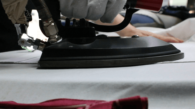 Fabric being ironed in a laundry shop