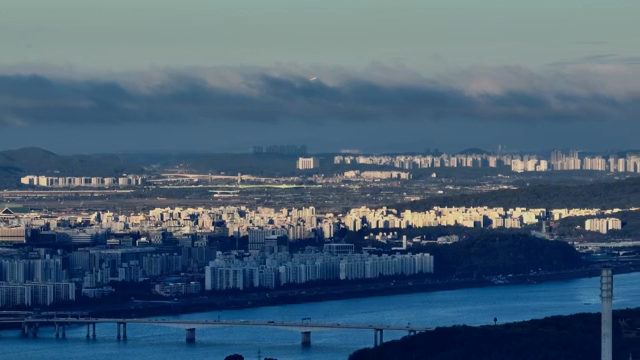A cityscape with a river and mountains