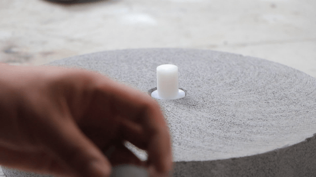 Hands assembling a basalt millstone