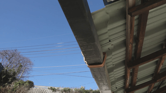 Roof and power lines under blue sky