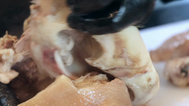 Hands preparing pork on a cutting board