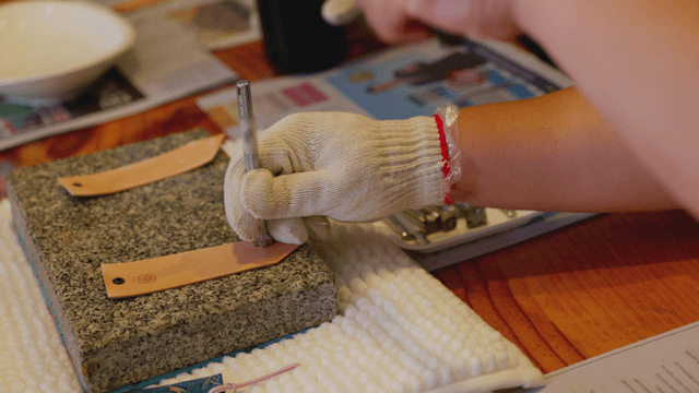 Hand stamping a leather tag with a hammer