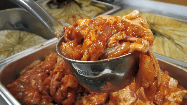 Ladle scooping stir-fried chicken