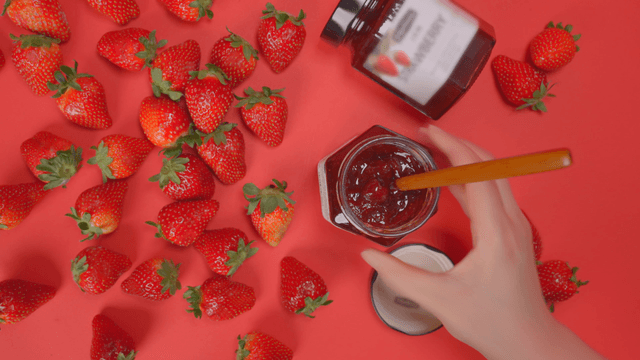 Strawberries and jam on a red background