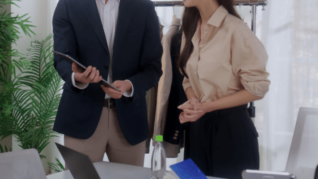 Two colleagues discussing work in an office