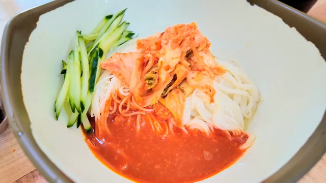 Spicy noodles with cucumber slices and Kimchi