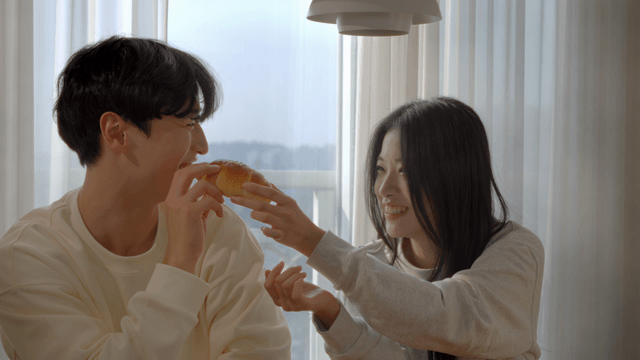 Couple smiling by window while smelling salt bread