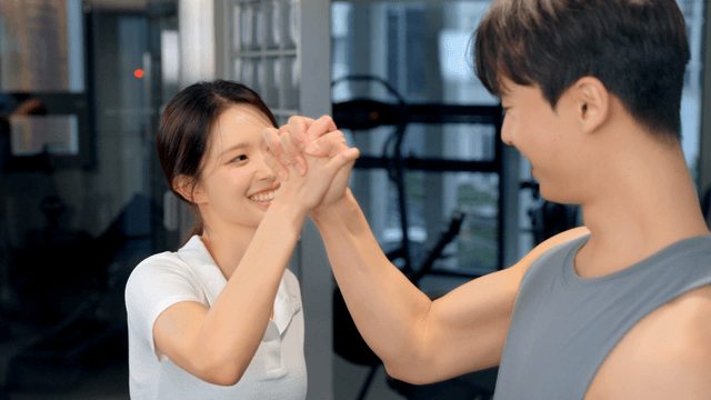 Couple encouraging each other while holding hands at gym
