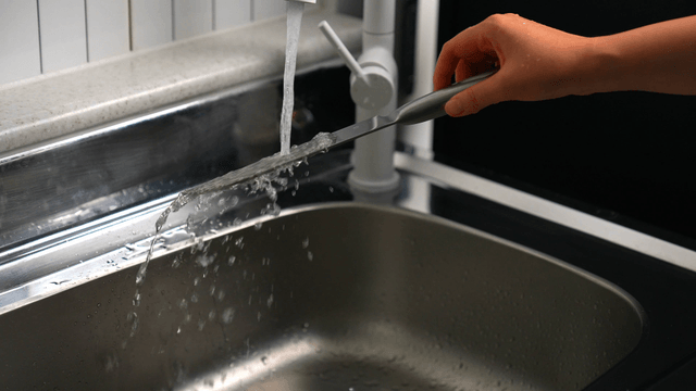 Washing a knife under running water