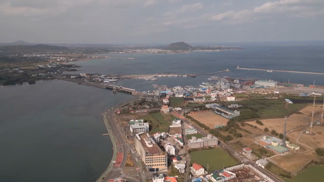 Coastal town with harbor and distant hills