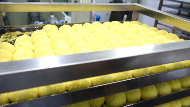 Yellow rice cake being prepared on a tray
