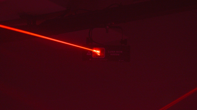 Red vibrant laser beams in dark club