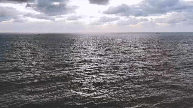 Calm ocean under a cloudy sky