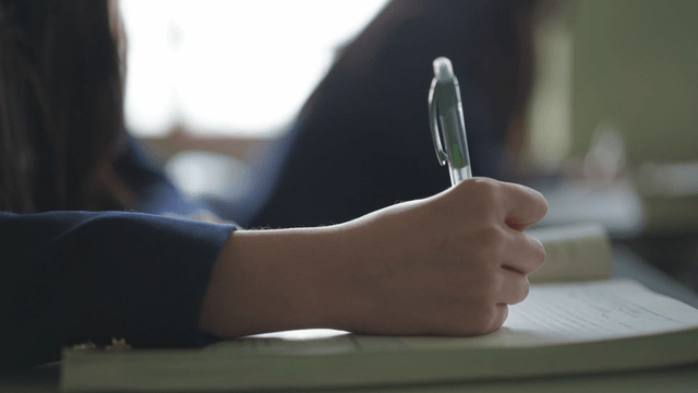 Student writing notes in a classroom