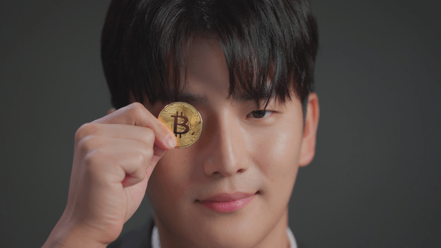 Man holding a bitcoin with a smile