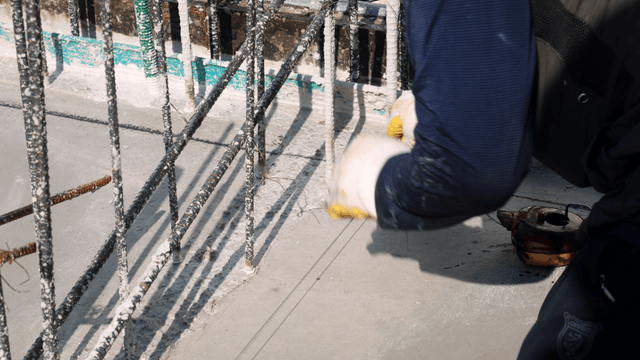 Worker marking concrete floor at a construction site