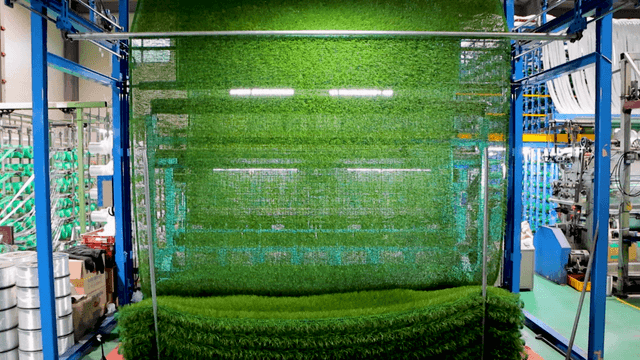 Large machine producing artificial turf