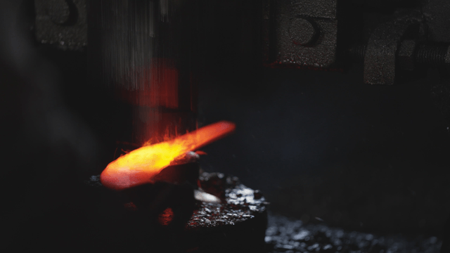 Hot metal forged quickly in workshop