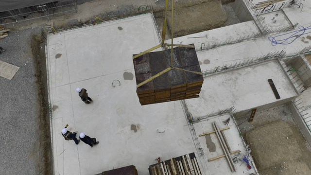 Construction workers guiding a crane load