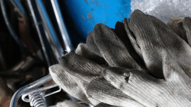 Worn work gloves on metal equipment