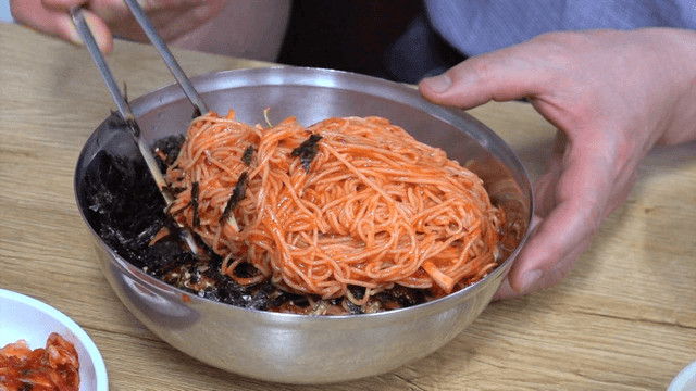 Spicy bibim noodles served with kimchi and seaweed