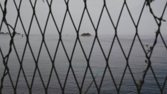 철망 너머로 흐린 날씨에 보이는 바다