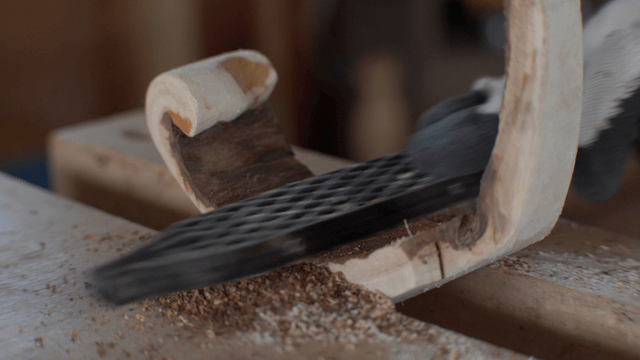 Wood piece being shaped with a rope
