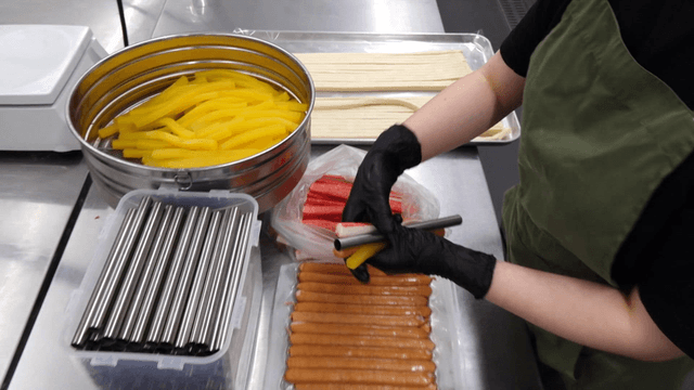 Chef stacking gimbap fillings with metal rod