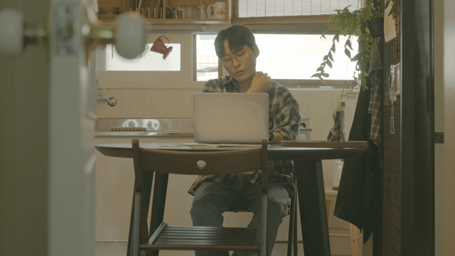 Person working on a laptop in a cozy kitchen
