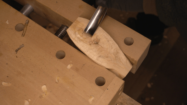 Woodcraft artisan carving wood with a chisel