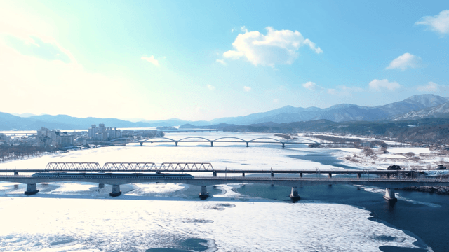 다리와 산이 있는 눈 덮인 강