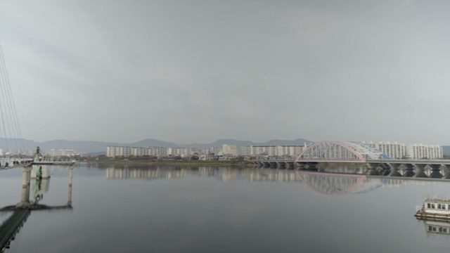 도시 풍경과 잔잔한 강 위의 다리