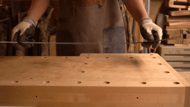 Metal artisan handling thin wire in workshop
