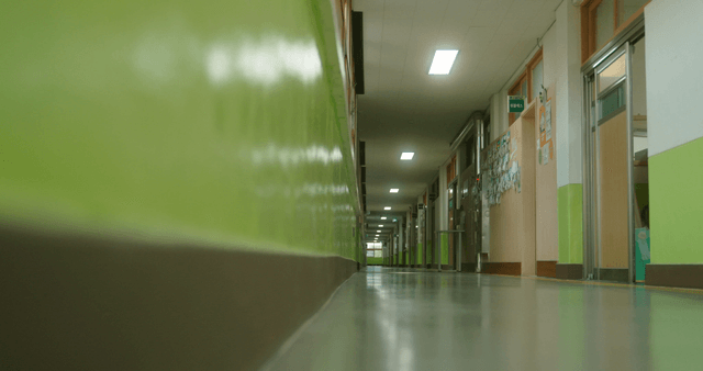 Empty school hallway with green walls