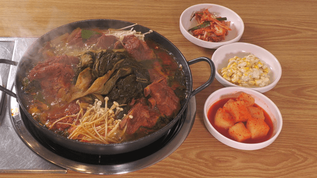 Table set with outer leaves pork back-bone stew and assorted side dishes