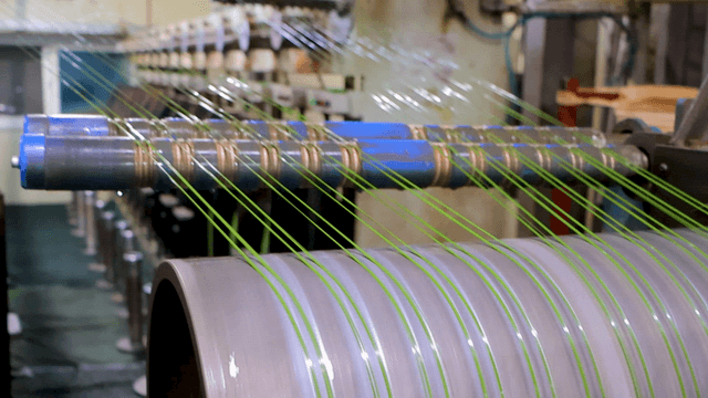 Machine drawing green threads in factory