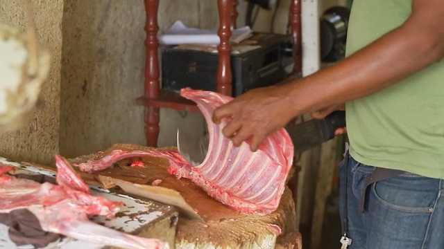 Butcher cutting meat on a wooden block