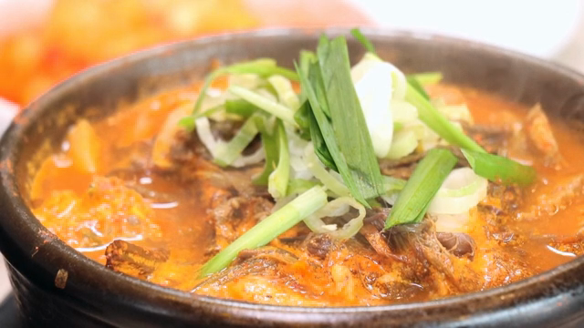 A steaming pot of Korean stew with vegetables