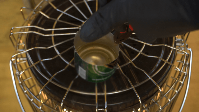 Can containing melted candle wax heating on a stove