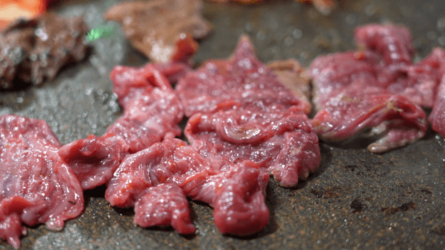 Raw beef pieces on hot grill