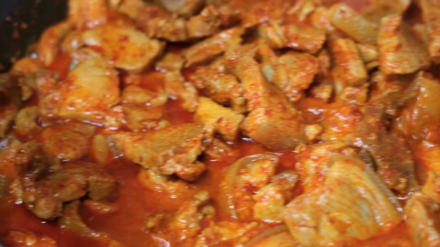 Spicy stir-fried pork simmering in a pot