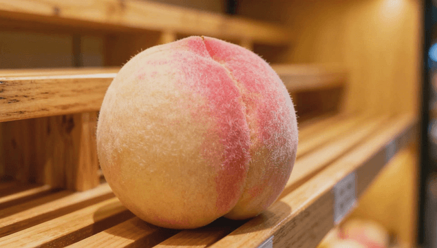 Ripe peach on a wooden shelf