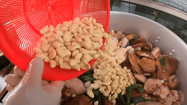 Garlic being added to a pot with mushrooms