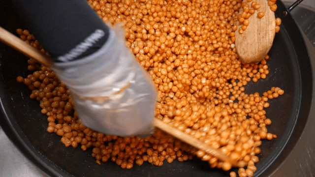 Scene of mixing snacks with honey in a pan