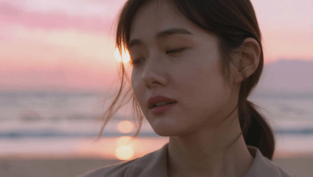 Young female facing sunset on beach
