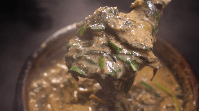 Spoon filled with rich and warm loach soup