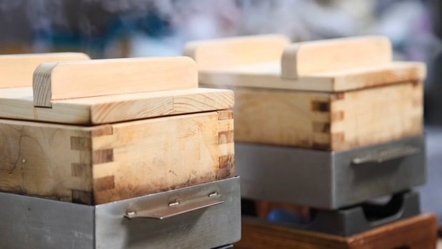 Wooden steamers on a stove with flames