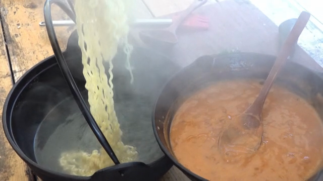 A scene where ramyeon is put into tomato sauce