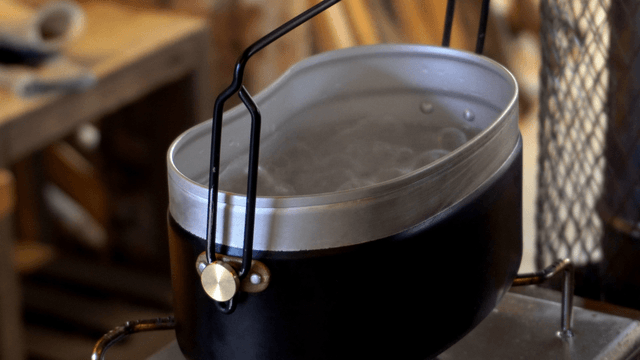 Mess tin boiling water on a workshop stove